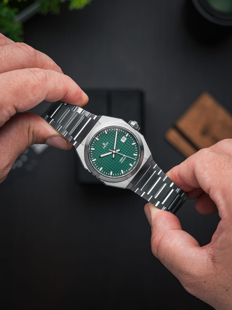 DWISS Model A1 watch with green dial being held by 2 hands 